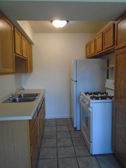 A kitchen with a white refrigerator and a white stove.